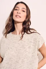 Chaleco de punto color crema con detalles en rosa y celeste, de corte holgado y mangas cortas.