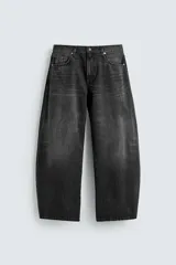 Jeans de hombre, corte balloon fit, tiro medio, confeccionados en denim de algodón rígido. Color negro lavado con efecto desgastado. Presentan cinco bolsillos y cierre frontal con cremallera y botón.