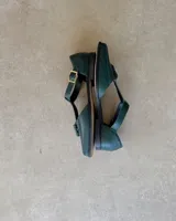 Mocasín negro de cuero vacuno, con punta cuadrada y detalle de borlas en el empeine.