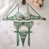 Conjunto de lencería de tul translúcido con bordado floral en verde profundo, compuesto por sostén con aro y colaless con tiras y portaligas.