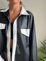 Camisa negra con estampado de piel de cocodrilo, detalles en blanco en cuello, solapa, bolsillos y puños.
