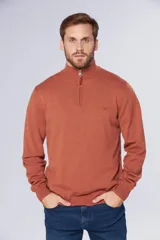 Buzo de tejido fino en hilo de algodón, color rosado, con cuello alto y cierre frontal parcial con detalle en cuero. Presenta puños y ruedo acanalados y un pequeño logo bordado en el pecho.