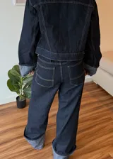 Pantalon de jean azul oscuro con costuras en contraste, corte wide leg y ruedo con doblez ancho en tono denim claro.