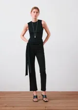 Jeans flare negros de tiro medio, confeccionados en denim elástico con diseño crop, trabillas para cinto, cinco bolsillos y cierre frontal con cremallera y botón.