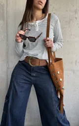 Remera de manga larga a rayas grises y blancas, de tejido acanalado, con cuello redondo y cartera de botones frontal.