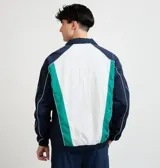 Campera deportiva Ellesse modelo Sako, diseño en bloques de color azul marino, blanco y verde, con cierre frontal completo, cuello alto y detalles de líneas blancas en las mangas.