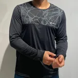 Remera de manga larga marca N+ color negro, con panel superior estampado en gris con diseño de líneas abstractas y logo de la marca en el pecho.