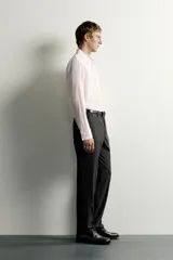 Camisa de corte regular fit color rosado pálido, con cuello solapa, manga larga y cierre frontal de botones.