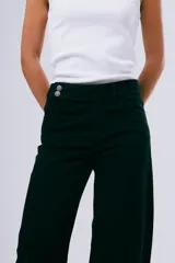 Pantalón wide leg negro, confeccionado en denim, con tiro alto y corte recto y amplio en las piernas.