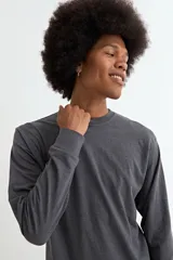 Remera de manga larga con cuello redondo, confeccionada en tejido de algodón y poliéster, con puños elásticos en las mangas.