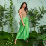 Falda larga color verde manzana de satén, con corte evasé y lazo en la cintura.