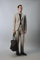 Blazer slim fit de color beige, confeccionada en tejido con lana. Presenta cuello con solapas de muesca, cierre frontal de un botón, bolsillos laterales con solapa y bolsillo de vivo en el pecho.