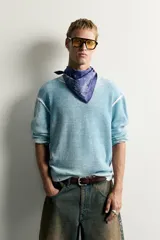 Jersey de punto de corte relaxed fit confeccionado en hilatura de algodón, con cuello redondo y manga larga. Presenta un diseño de efecto lavado con costuras en contraste y acabados en rib.