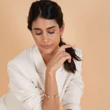 Medio aro de oro 18k con perla de cultivo colgante. Diseño minimalista y elegante.