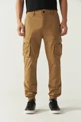 Pantalón cargo color marrón claro, con corte regular, puños elásticos y bolsillos laterales con solapa.