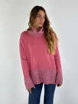 Sweater rosa de cuello alto con detalles brillantes en el cuello, puños y bajo.