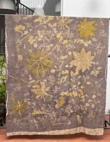 Mantel rectangular de algodón color gris con estampado de hojas y flores en tonos amarillos y marrones.