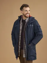 Campera de abrigo azul marino con capucha, cierre frontal con botones y cremallera, múltiples bolsillos y forro interior naranja.