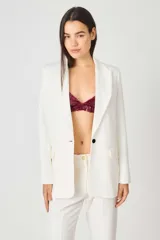 Blazer sastrero color blanco, de corte recto, con solapas de muesca, cierre frontal con un botón, bolsillos delanteros y abertura en la espalda.