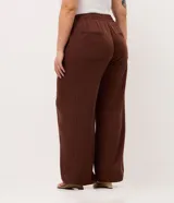 Pantalón palazzo marrón de talle alto y pierna ancha, confeccionado en sarga de algodón y liocel, con cintura elástica y bolsillos laterales.