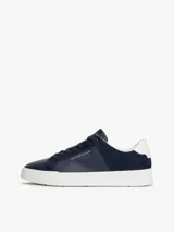 Zapatillas de corte bajo Tommy Hilfiger, confeccionadas en una combinación de piel nobuk y piel lisa en color azul marino. Presentan suela de goma blanca, cierre con cordones y detalles de la marca en el lateral, lengüeta y talón.