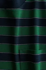 Remera de punto a rayas horizontales en color verde y azul marino, con cuello redondo, mangas largas de hombros caídos y un bolsillo de parche en el pecho.