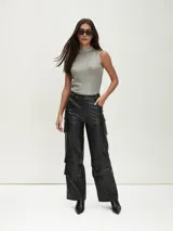Pantalón negro de cuero sintético, corte ancho, con bolsillos cargo y tiro alto.