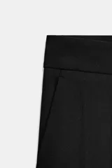 Pantalón de corte carrot con pinzas delanteras, tiro bajo y cierre frontal con cremallera y botón. Cuenta con bolsillos laterales y falsos bolsillos traseros de vivo.