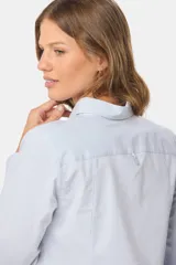 Camisa de manga larga entallada, confeccionada en una mezcla de algodón con spandex. Presenta cuello clásico, cierre frontal con botones al tono y puños abotonados.