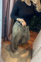 Pantalón de corte recto con estampado animal print en tonos beige y gris. Presenta cintura elástica y diseño holgado.