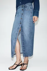 Falda midi de denim azul con diseño cruzado, cierre frontal con botones metálicos y bolsillos delanteros.