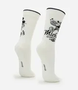 Medias de caña larga color blanco con borde superior negro, confeccionadas en tejido acanalado. Presentan un estampado lateral de Mickey Mouse con lettering en color negro.