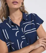 Mono largo Marfinno de color azul marino con estampa geométrica en color blanco, de corte estilo aladín con mangas cortas, cuello camisero, cierre frontal con botones y puños ajustados en los tobillos. Incluye un cinturón de cuerda ajustable en la cintura con nudos y detalles de esferas en las puntas.