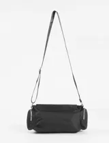 Bandolera de tela color verde militar, con tapa frontal y hebilla metálica. Cuenta con correa regulable y bolsillos laterales con cierre.