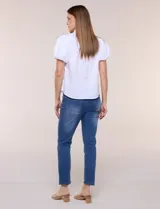 Camisa blanca de calce recto confeccionada en algodón elástico, con cuello mao, abertura frontal en V y cartera con botones ocultos. Presenta mangas cortas abullonadas con puños elastizados y ruedo redondeado.