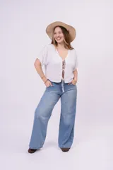 Pantalón wide leg de denim rígido, de tiro bajo en color celeste claro con sutiles desgastes, pernera ultra ancha y diseño de cinco bolsillos.