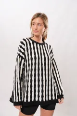 Buzo tejido de algodón con rayas verticales blancas y negras, de corte oversize.