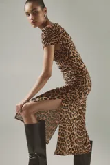 Vestido midi entallado de punto elástico con estampado de leopardo. Presenta un diseño asimétrico de un solo hombro con un bretel ancho y detalle de fruncido en la manga. Incluye tajos laterales en el ruedo.