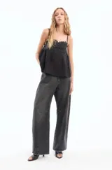 Pantalón de jean negro de corte ancho con costuras marcadas en las rodillas.