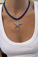 Collar de hilo azul de algodón trenzado con dije colgante en forma de estrella de mar de acero.