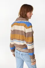 Cardigan de punto a rayas horizontales en tonos marrón, blanco, mostaza y azul, con cuello camisero de crochet, mangas largas y cierre frontal de botones.