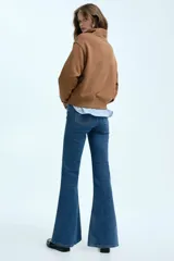 Jean de tiro alto con corte acampanado desde la rodilla, confeccionado en denim con leve stretch. Presenta cierre frontal de botones y diseño clásico de cinco bolsillos.