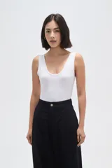 Body de poliamida al cuerpo con breteles anchos, cuello profundo y cierre con broches en la parte inferior.