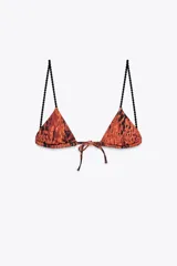 Top de bikini triangular con estampado animal print en tonos terracota y negro. Presenta tirantes finos negros con textura de cuentas que contrastan con el cuerpo del top. Se anuda en la espalda y en el centro del busto.