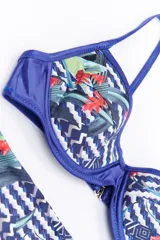 Bikini de dos piezas en combinación de colores negro y mostaza. El corpiño es de estilo triangular con base y breteles finos, mientras que la bombacha es de corte clásico con cintura alta en color negro.