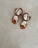 Sandalia de taco cuadrado alto, con diseño de punta cuadrada, tira delantera ancha y tira ajustable en el tobillo con hebilla metálica.