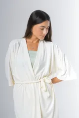 Bata estilo kimono de algodón en color gris azulado, con mangas al codo y largo por encima de la rodilla. Incluye lazo de ajuste en la cintura.