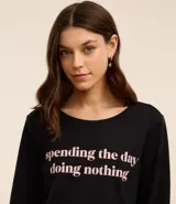Blusa de pijama negra de algodón con cuello redondo, mangas largas y estampa frontal con la frase "spending the day doing nothing".