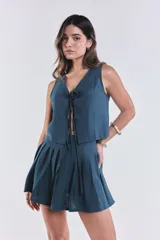 Chaleco azul petróleo con escote en V y lazo ajustable en el frente.