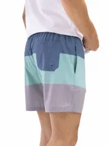 Short de baño de secado rápido, con cintura elástica y cordón ajustable. La parte superior es de color verde agua con un estampado de motivos circulares en tono azul oscuro. La parte inferior es de color terracota con un patrón de microperforaciones.